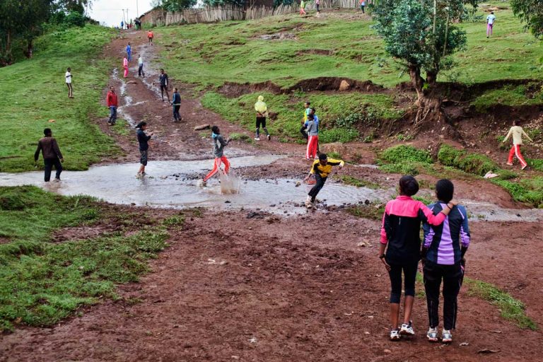 Bekoji, Ethiopia. August 2013. At the end of the daily training, on the way back home, runners have fun playing in the stream between the forest and the town.